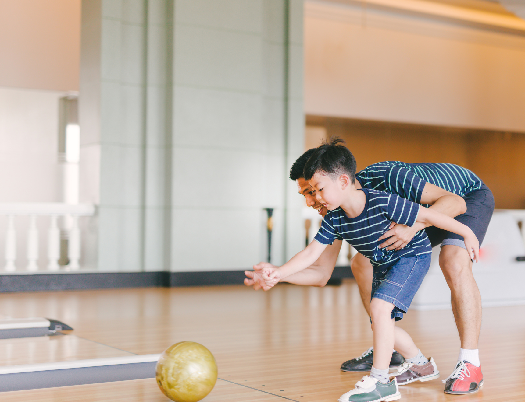 Asian family having fun at bowling club
